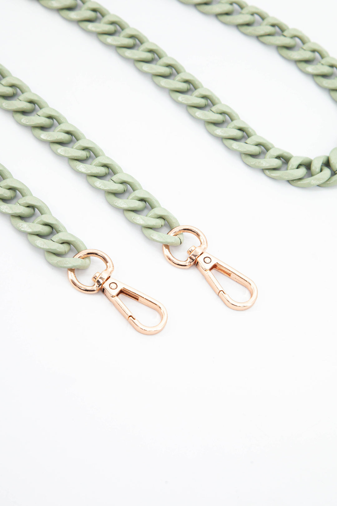 close up of the gold snap hooks and green chain link 