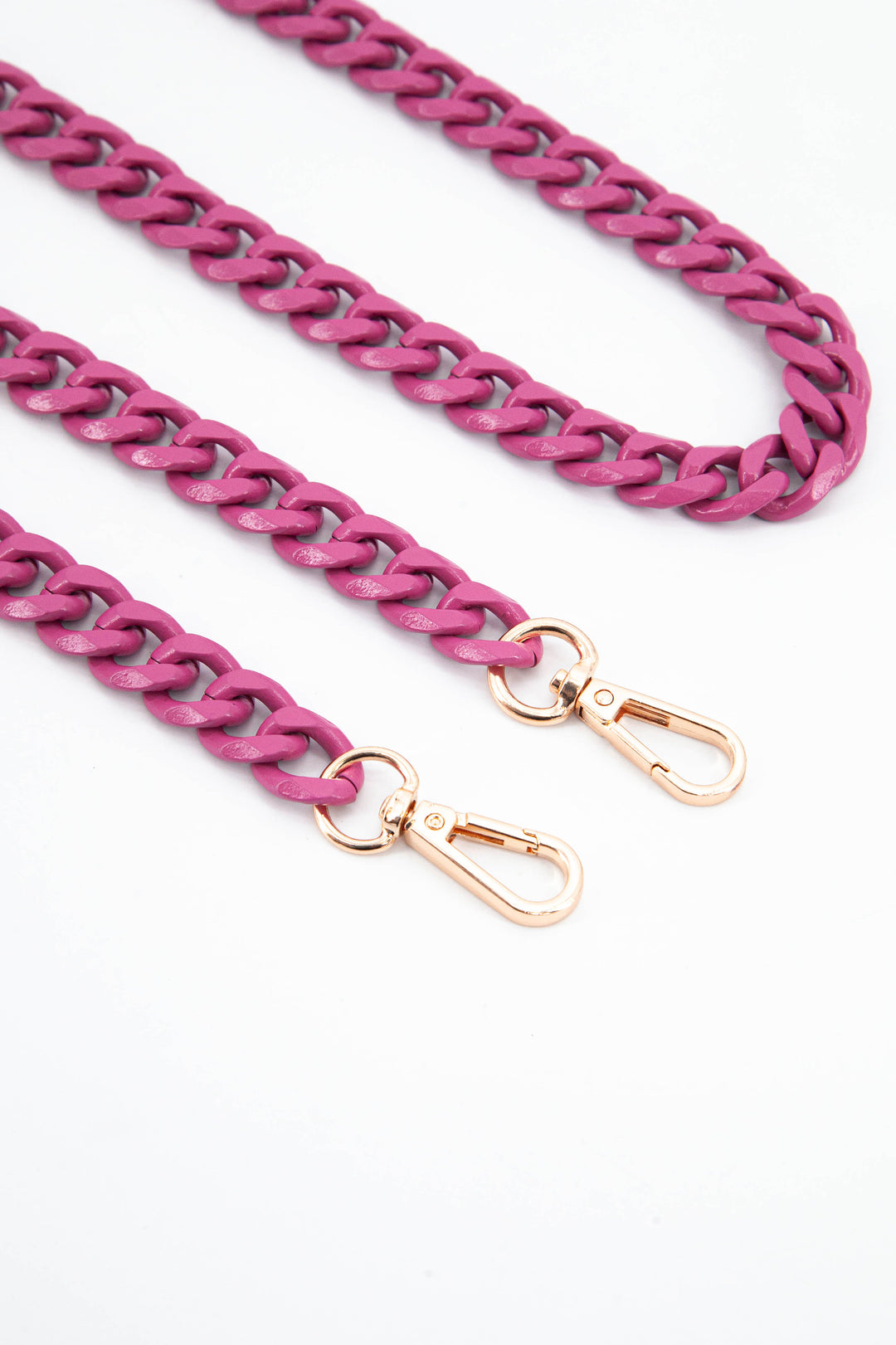 close up of the gold snap hooks and pink chain link 