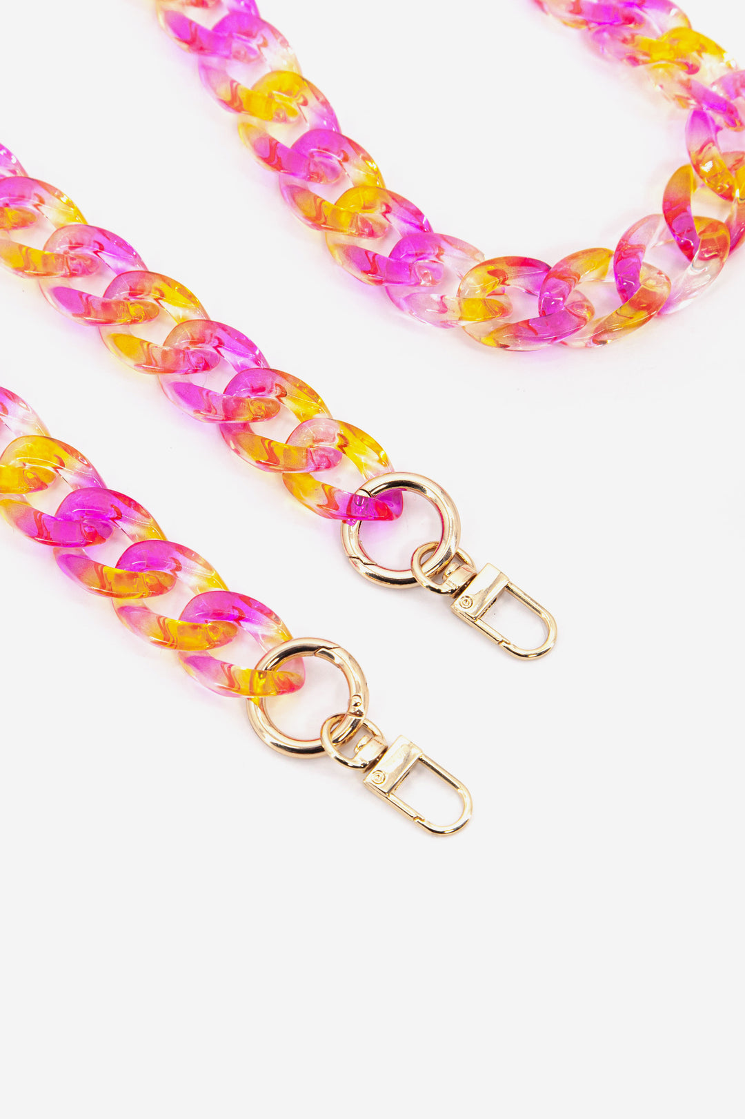 close up of the gold clip on attachments on the pink and orange acrylic bag strap