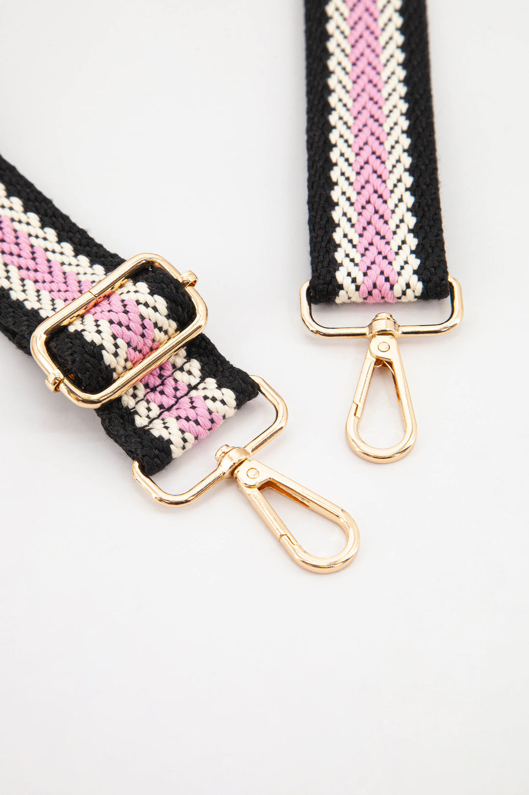 close up of the gold clip on snap hooks and woven material
