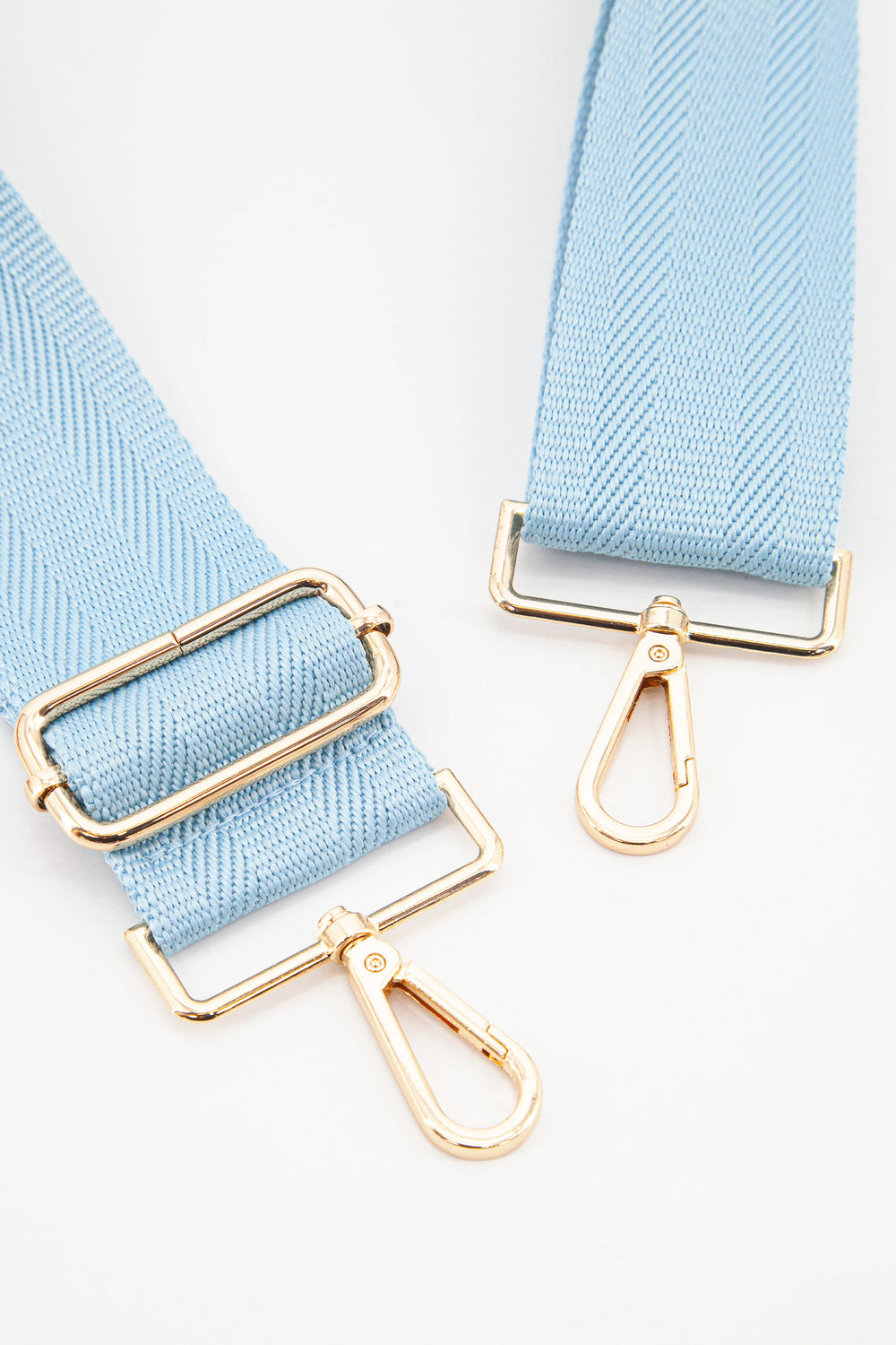 close up of the gold snap hook attachments and the baby blue colour of the strap