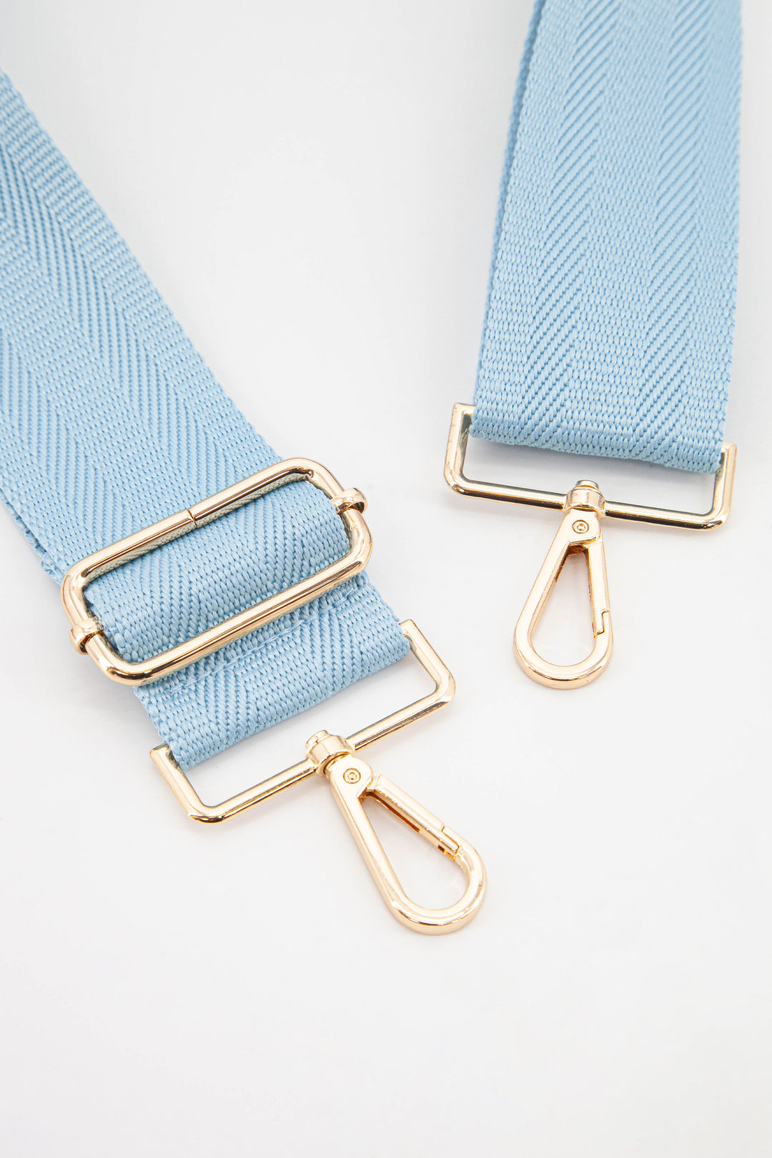 close up of the gold snap hook attachments and the baby blue colour of the strap