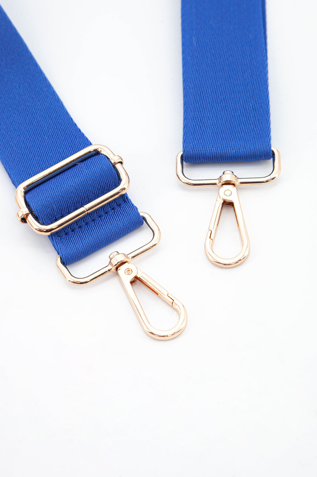 close up of the gold snap hook attachments and the vibrant blue colour of the strap