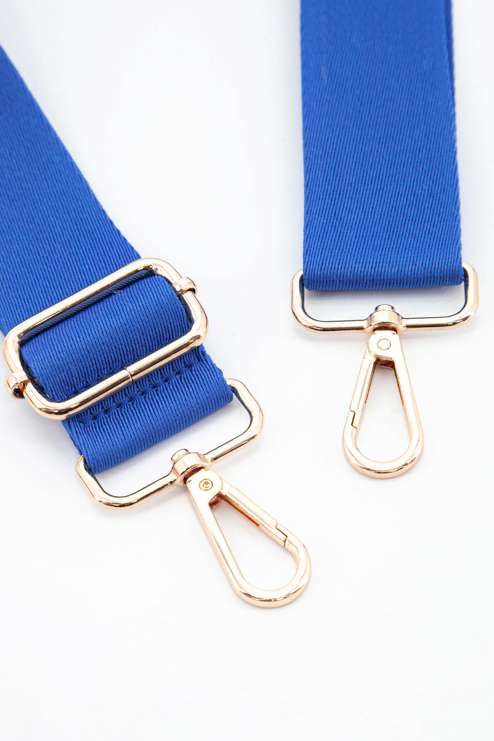 close up of the gold snap hook attachments and the vibrant blue colour of the strap