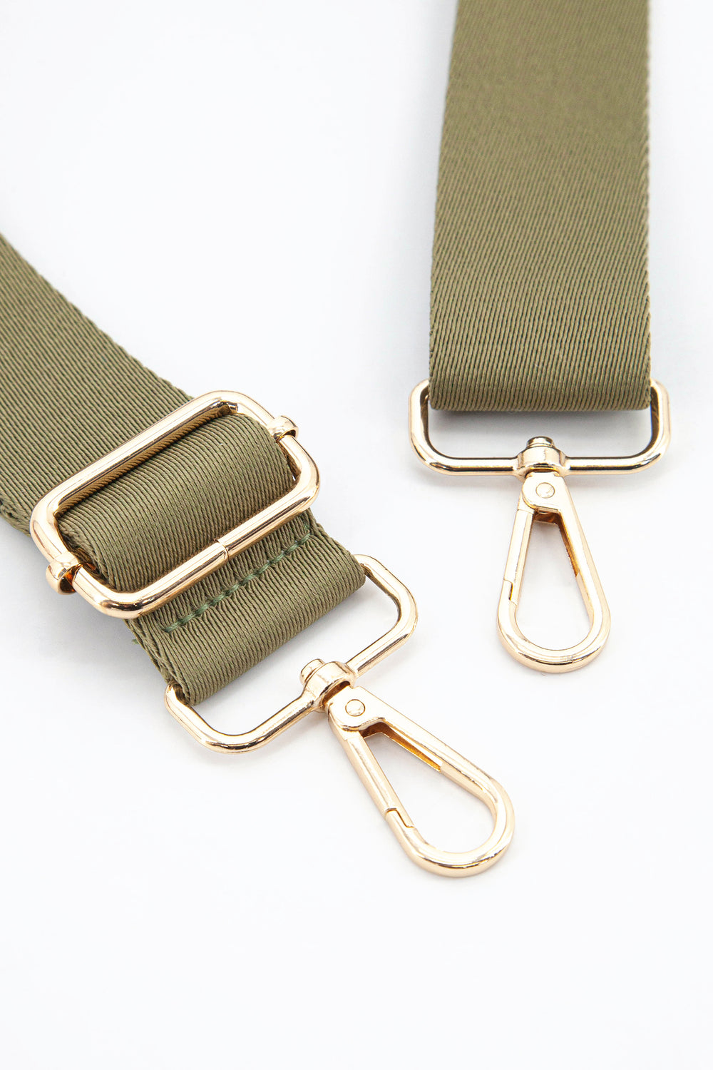 close up of the gold snap hook attachments and the khaki colour of the strap