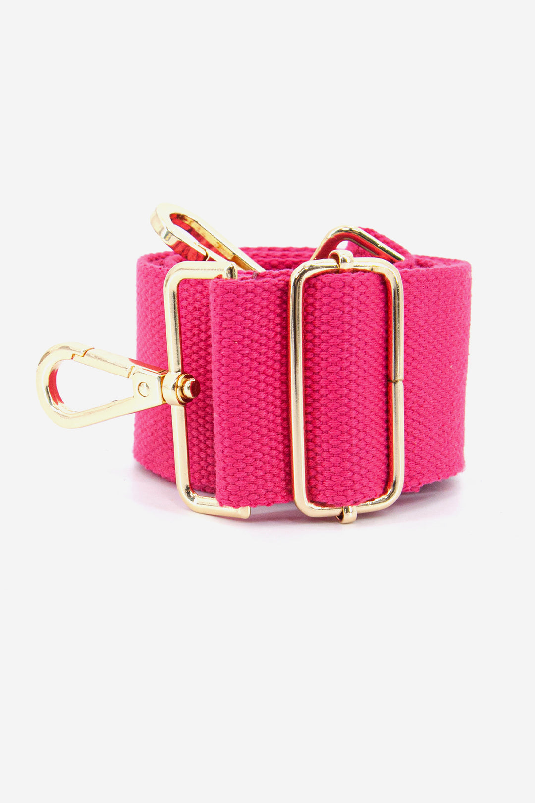 showing the bag strap coiled around itself, the fuchsia pink woven design is prominent , the gold hardware is shown in close up