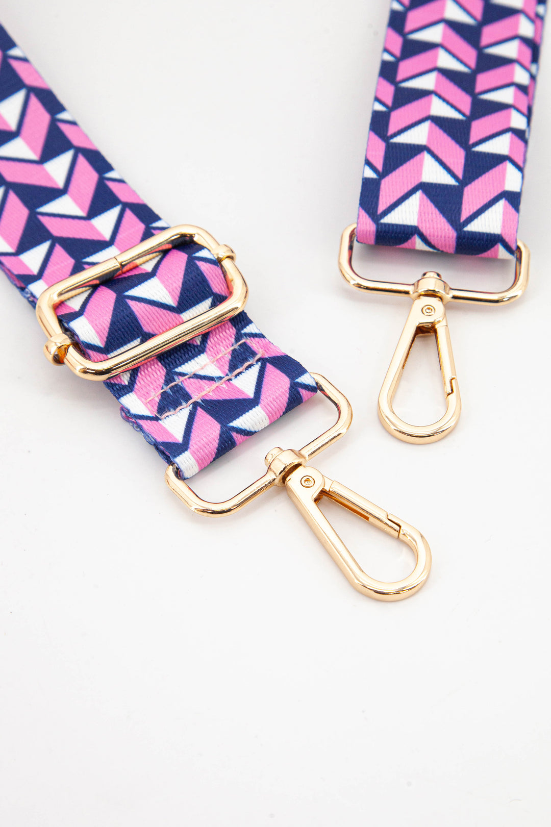 close up of the gold clip on snap hook attachments and the pink and navy blue 3d effect chevron pattern