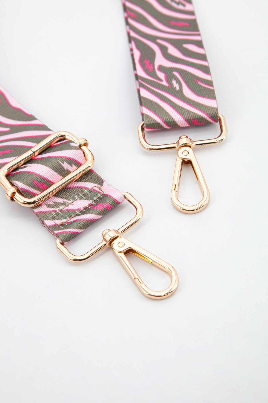 close up of the gold hardware, clip on snap hooks which can be used to attach the bag strap to any bag