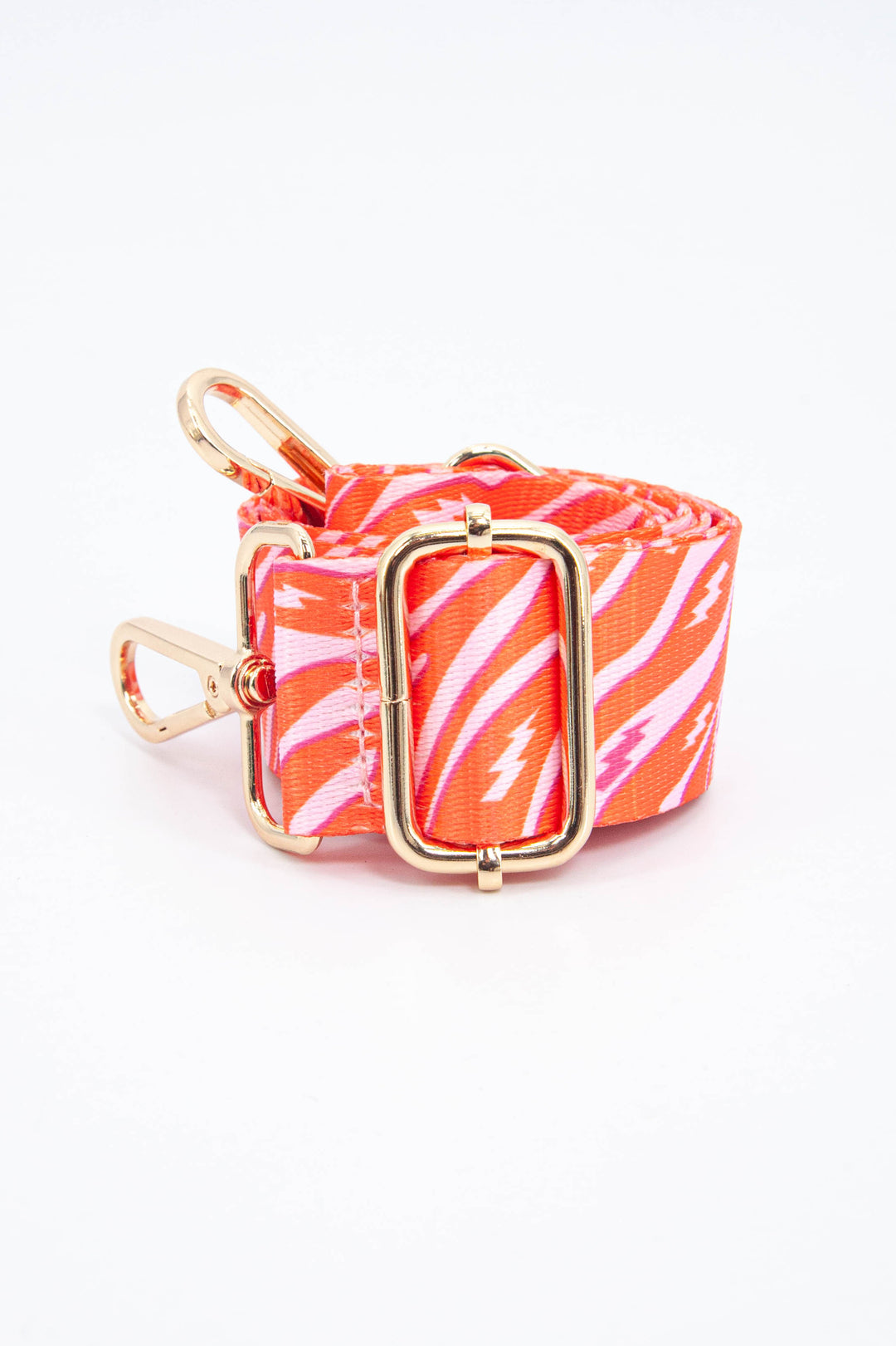 close up of the orange and pink zebra and lightning bolt pattern and adjustable gold buckle 