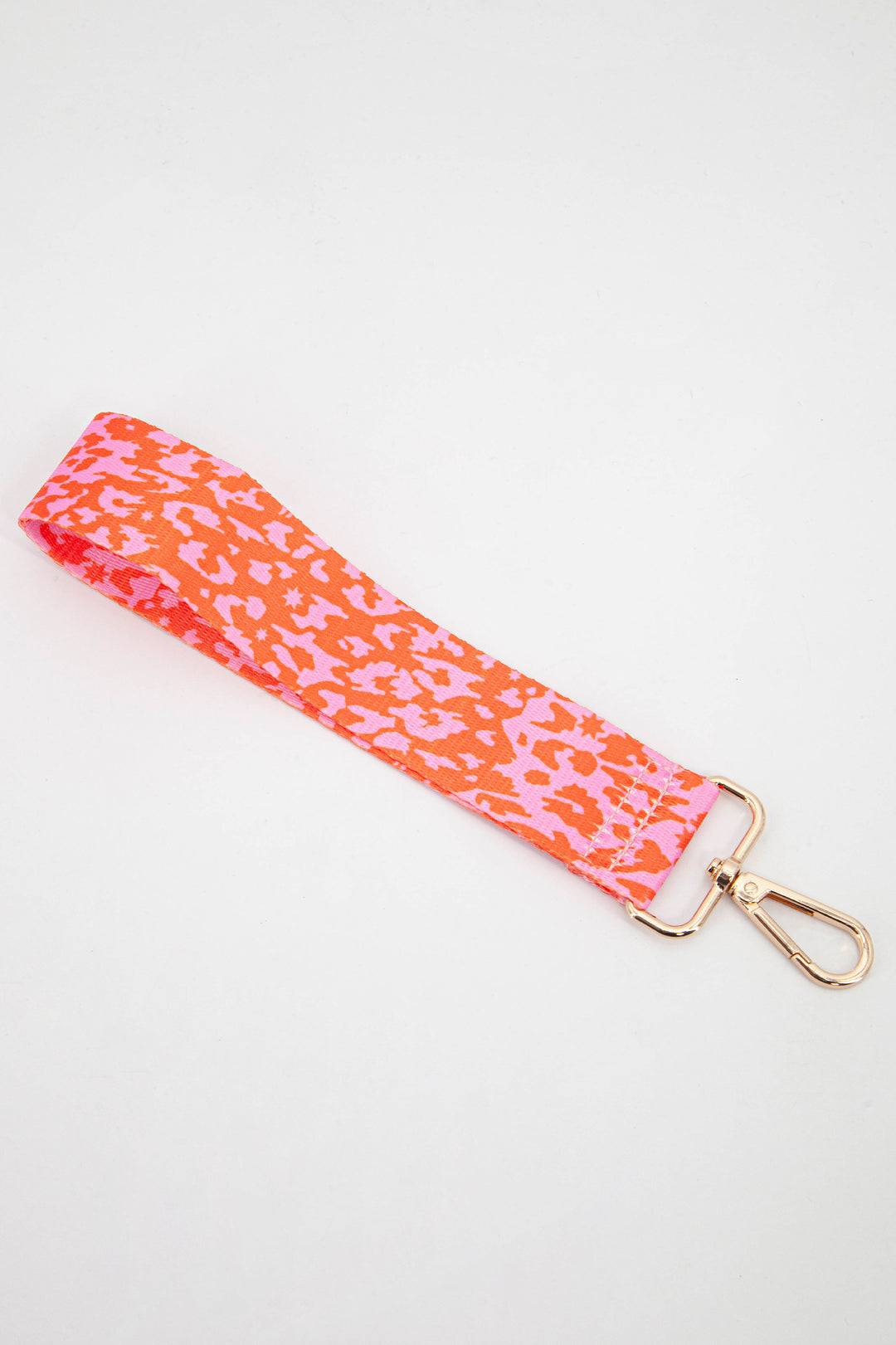 pink and orange leopard print wristlet bag strap with a subtle scattered star pattern throughout the design