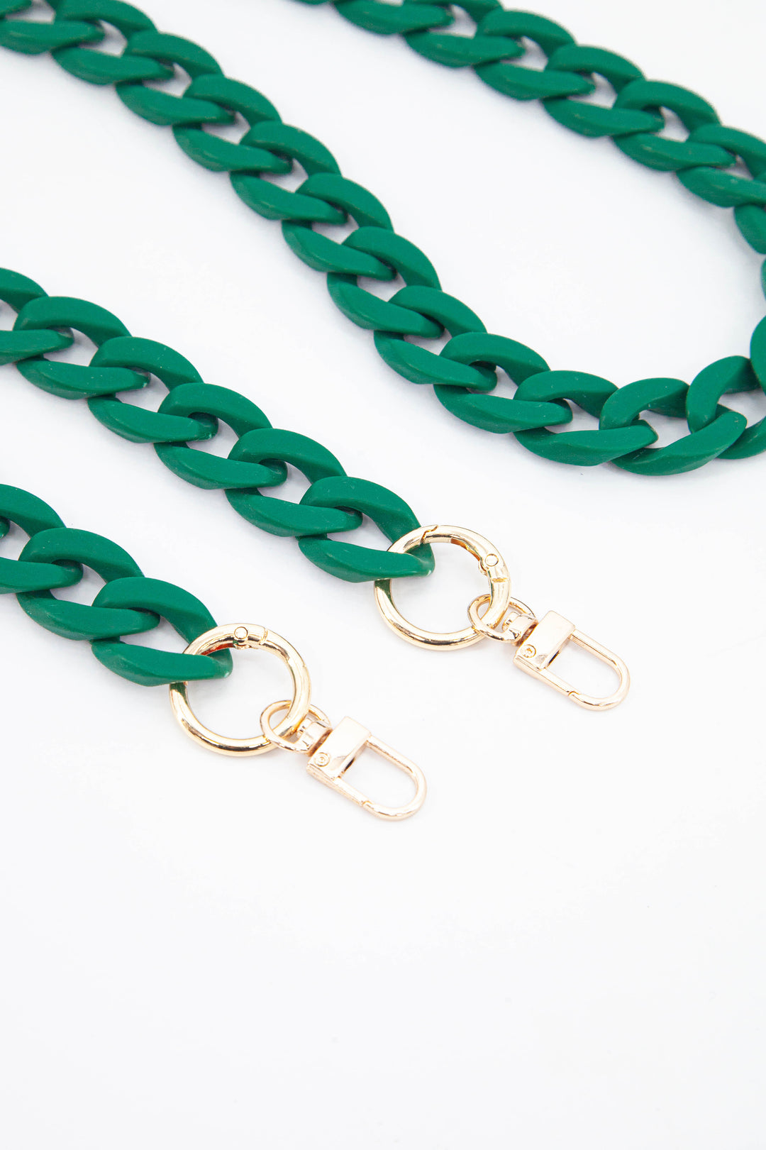 close up of the gold clip on attachments and a close up of the green cuban style acrylic bag strap