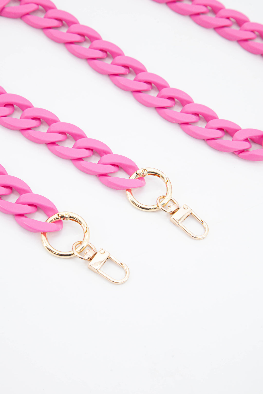 close up of the gold clip on attachments and a close up of the pink cuban style acrylic bag strap