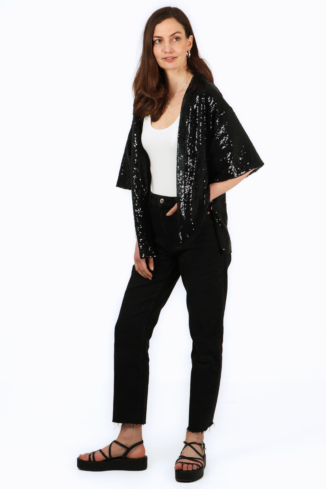 model wearing a black sequin evening kimono jacket with 3/4 sleeves and an all over sparkle effect 1