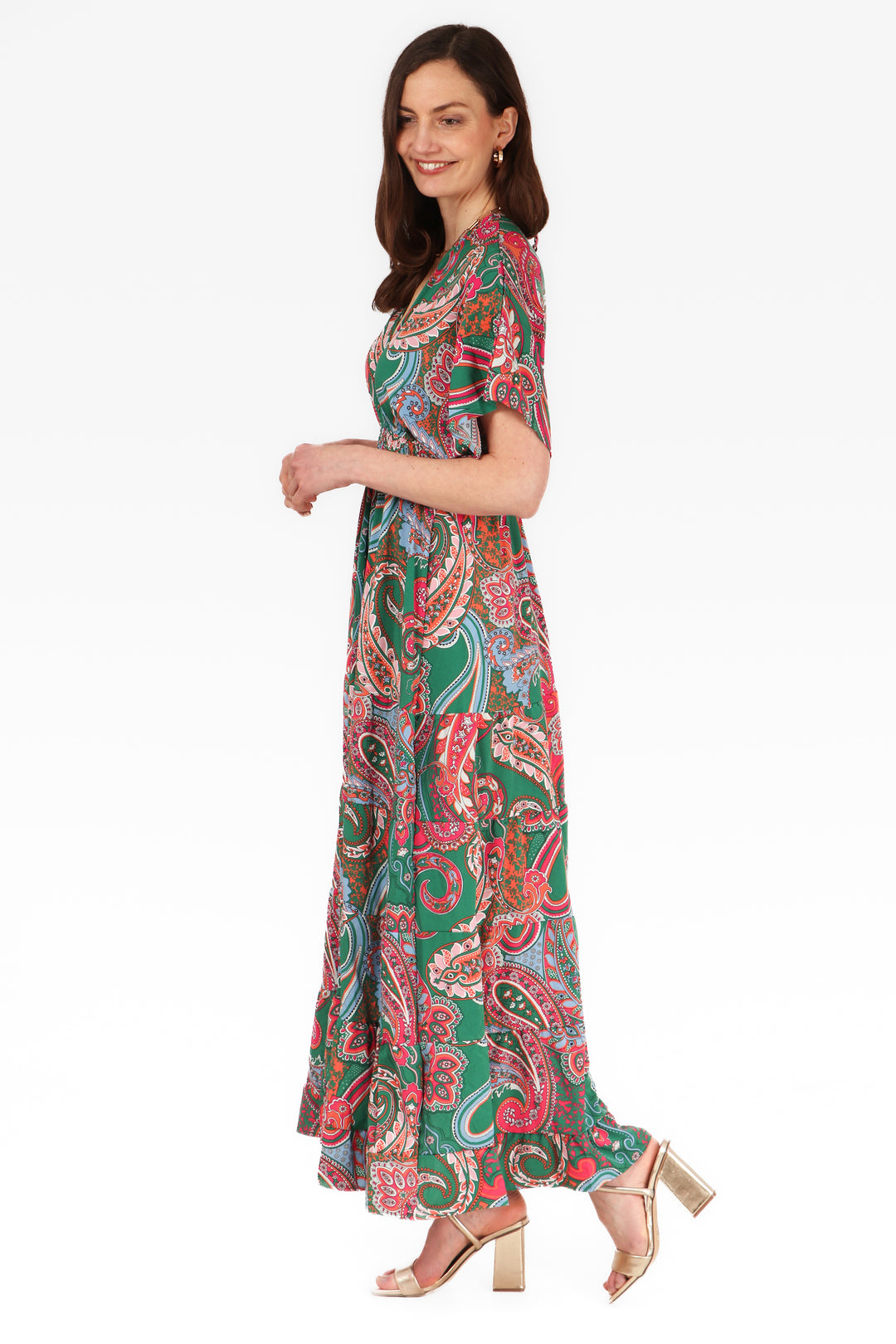 model showing the side view of the green and pink maxi kaftan dress, showing the elbow length sleeves and tiered hem 