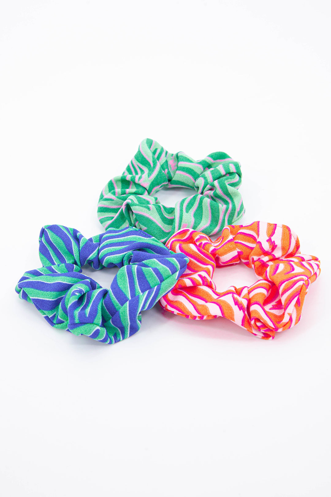 showing three available colours of this lighting bolt and zebra print scrunchie, green, blue and pink