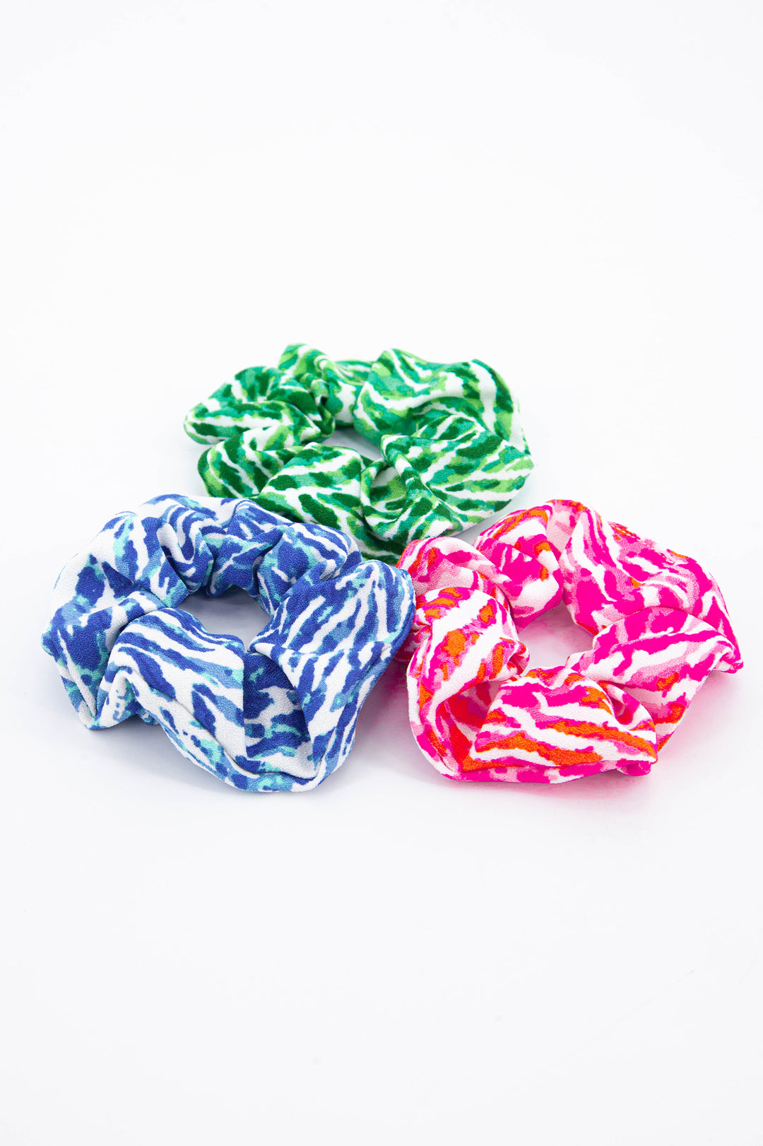 showing the three colourways of painted chevron pattern scrunchies, blue, pink and green