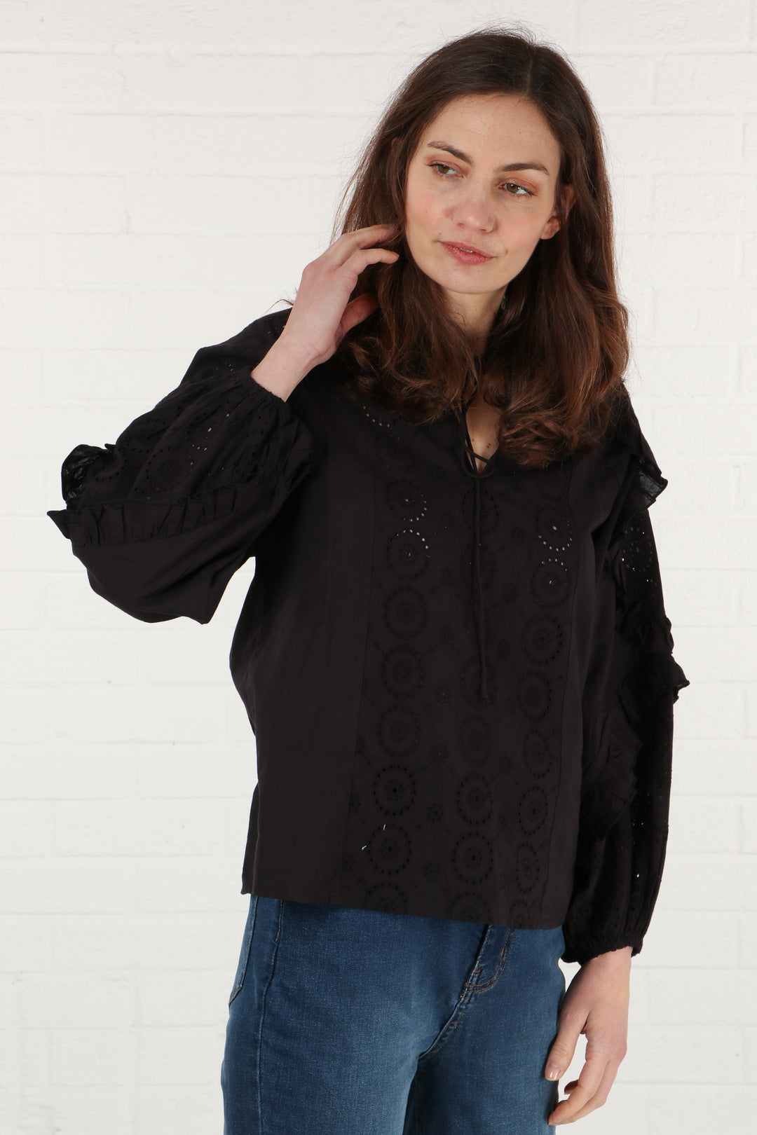 model wearing a black long sleeve cotton summer shirt with frill sleeves and broderie anglaise details