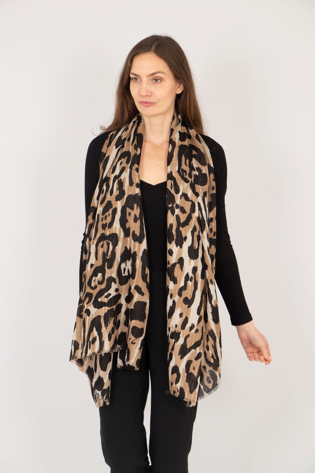 model wearing a neutral leopard print scarf draped around her neck and shoulders, showing the all over pattern and subtle metallic stripe