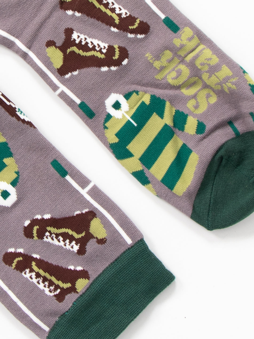 close up of the cuff and toe on the rugby bamboo socks. the toe and cuff are dark green and contrast the grey background of the design.