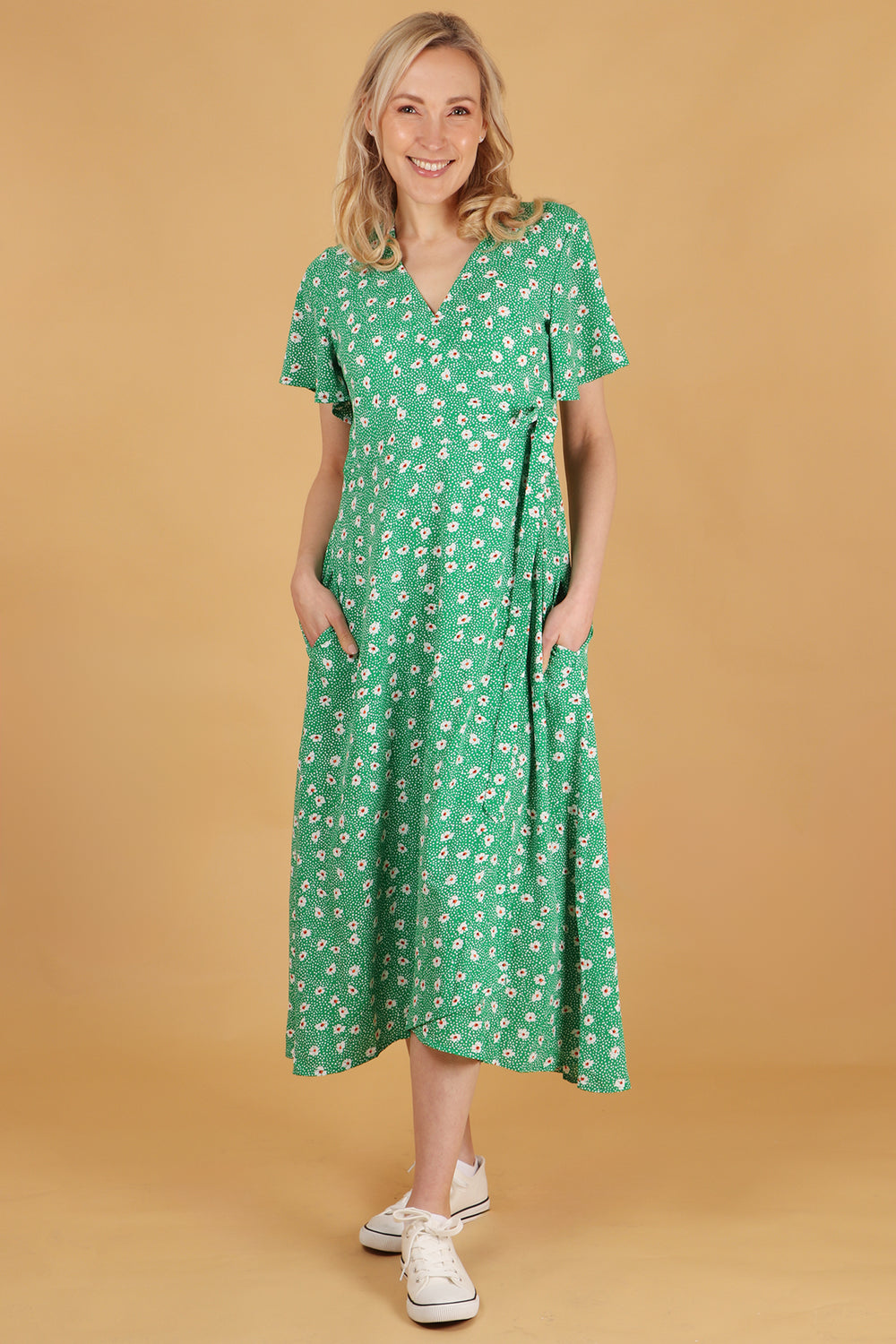 model showing that the daisy print wrap dress has pockets