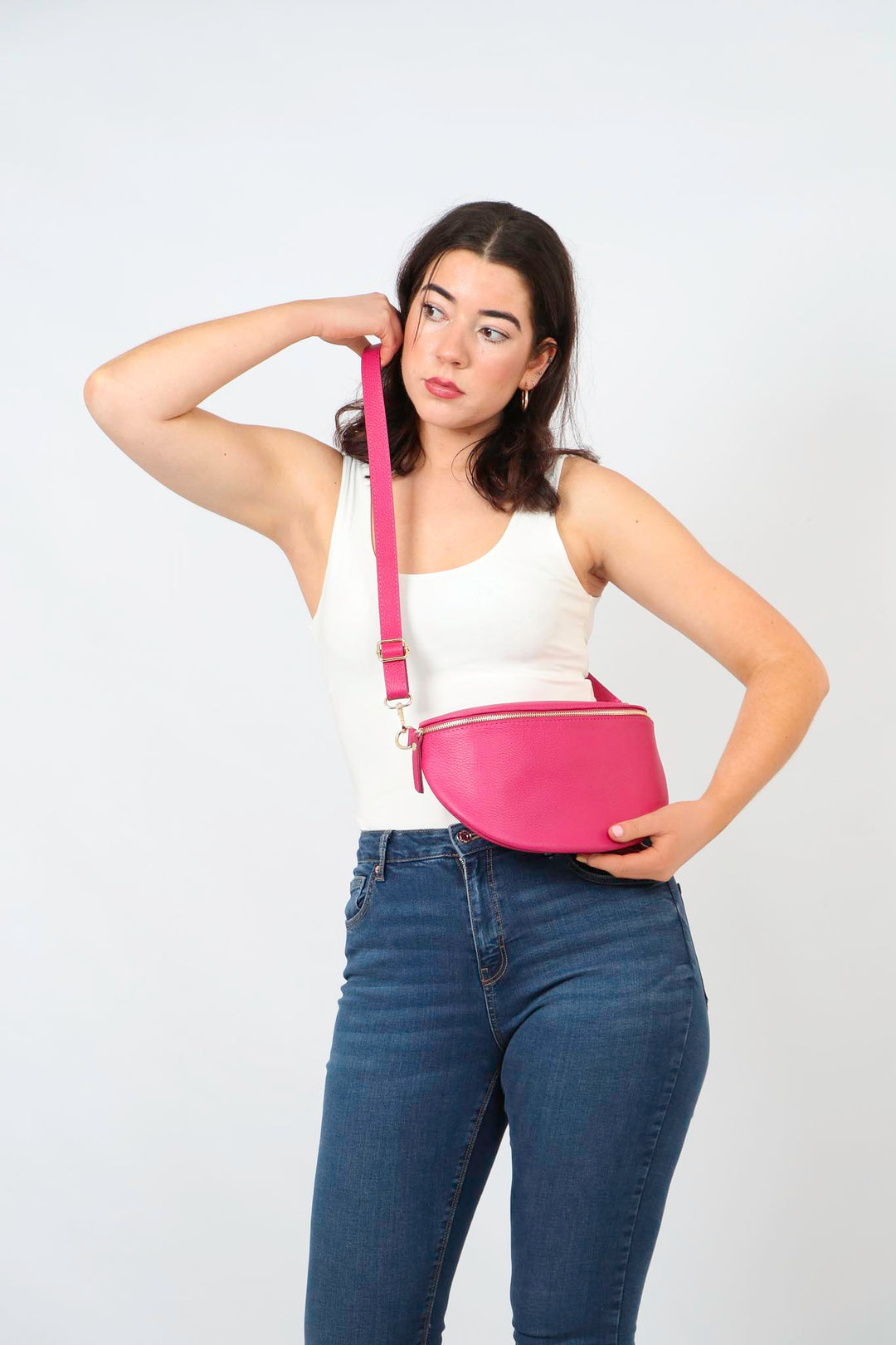 model wearing a large fuchsia pink pebbled leather crossbody bag